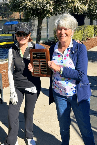 Sherry Benz handing the trophy to Silver Creek Golf & Country Club.