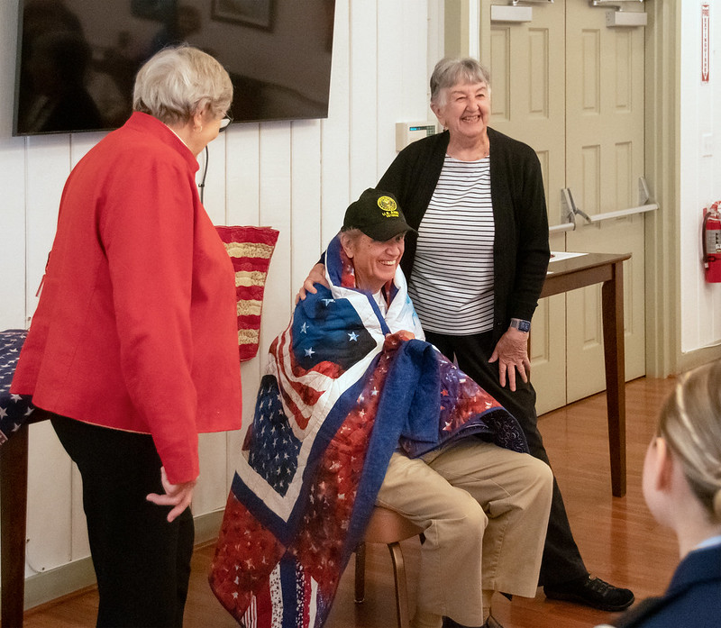 Lorraine Navone presents a quilt to Paul Miner