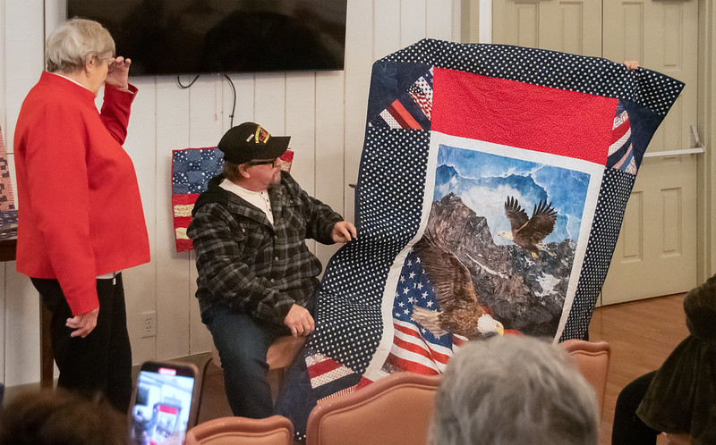 Sandy Juracich presents a quilt to James Halliwell.