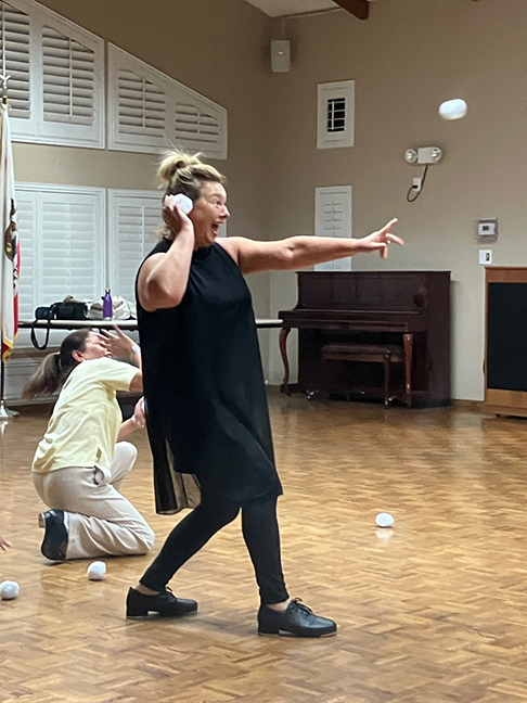 Dancing Queen member Elena Johal aims with gusto during “A Winter Spectacular” rehearsal. Lorelie Garcia ducks to avoid a high-spirited, cold blast.