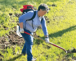 Hiking Trail Theresa digging. General Manager Teresa Ostrander volunteering on a previous on a Trail Maintenance Day.