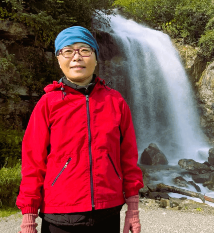 Lisa Yanfu Guo in front of a waterfall