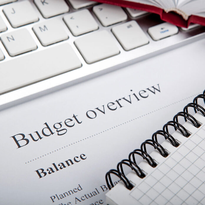 budget overview sheet laying on keyboard